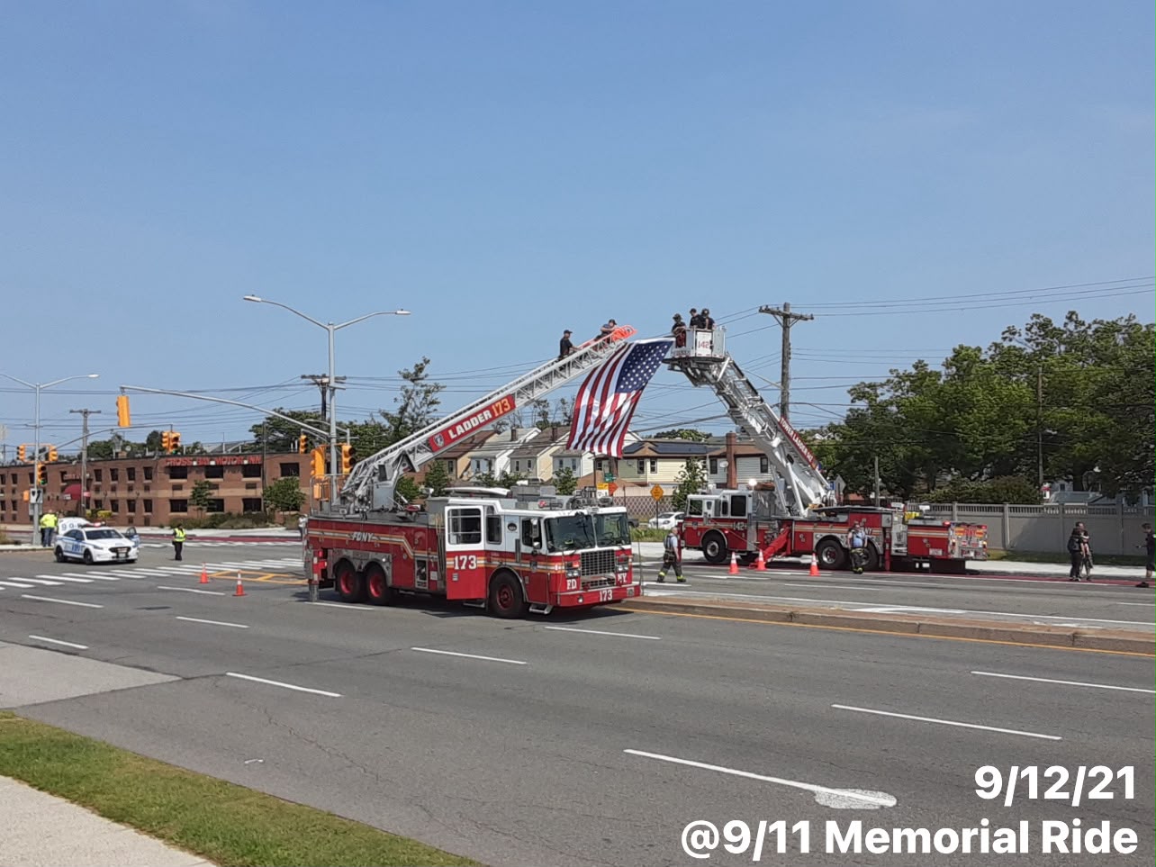 FDNY ladder companies raise a large American flag over the parade route